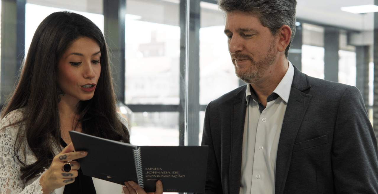 Nicolle apresentando o livro estratégico da Tuna para um cliente
